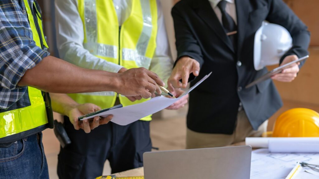 Architect and engineer work together with sketch of the building and discussing at construction site