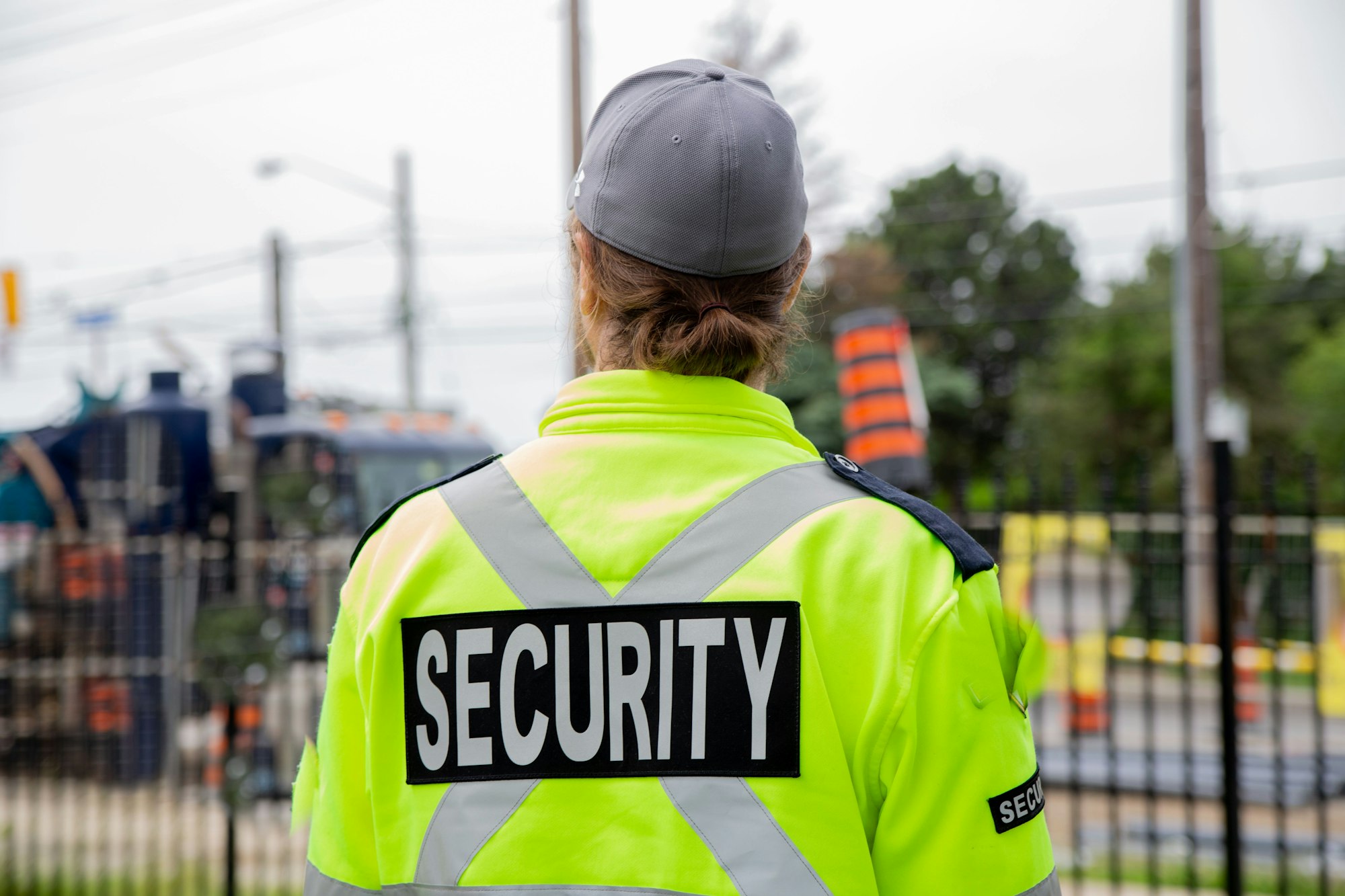 Closeup back shot of a security guard patrolling the street next to the construction area