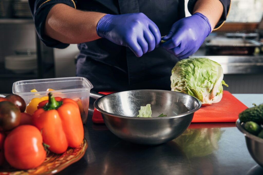 cropped shot of chef cooking vegetables at workplace in restaurant