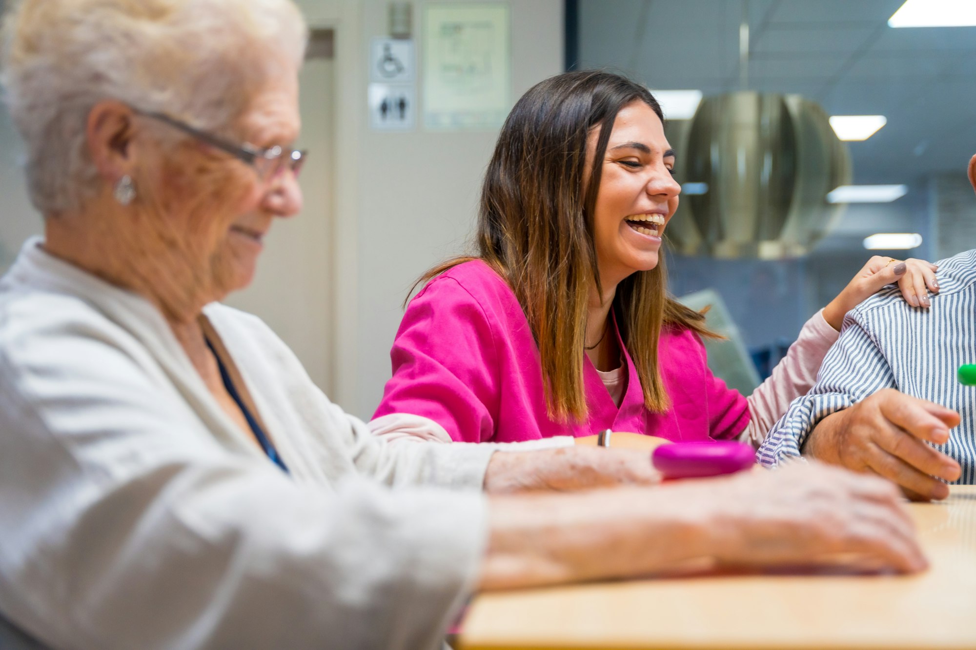 Happy elder people playing board game in a nursing home