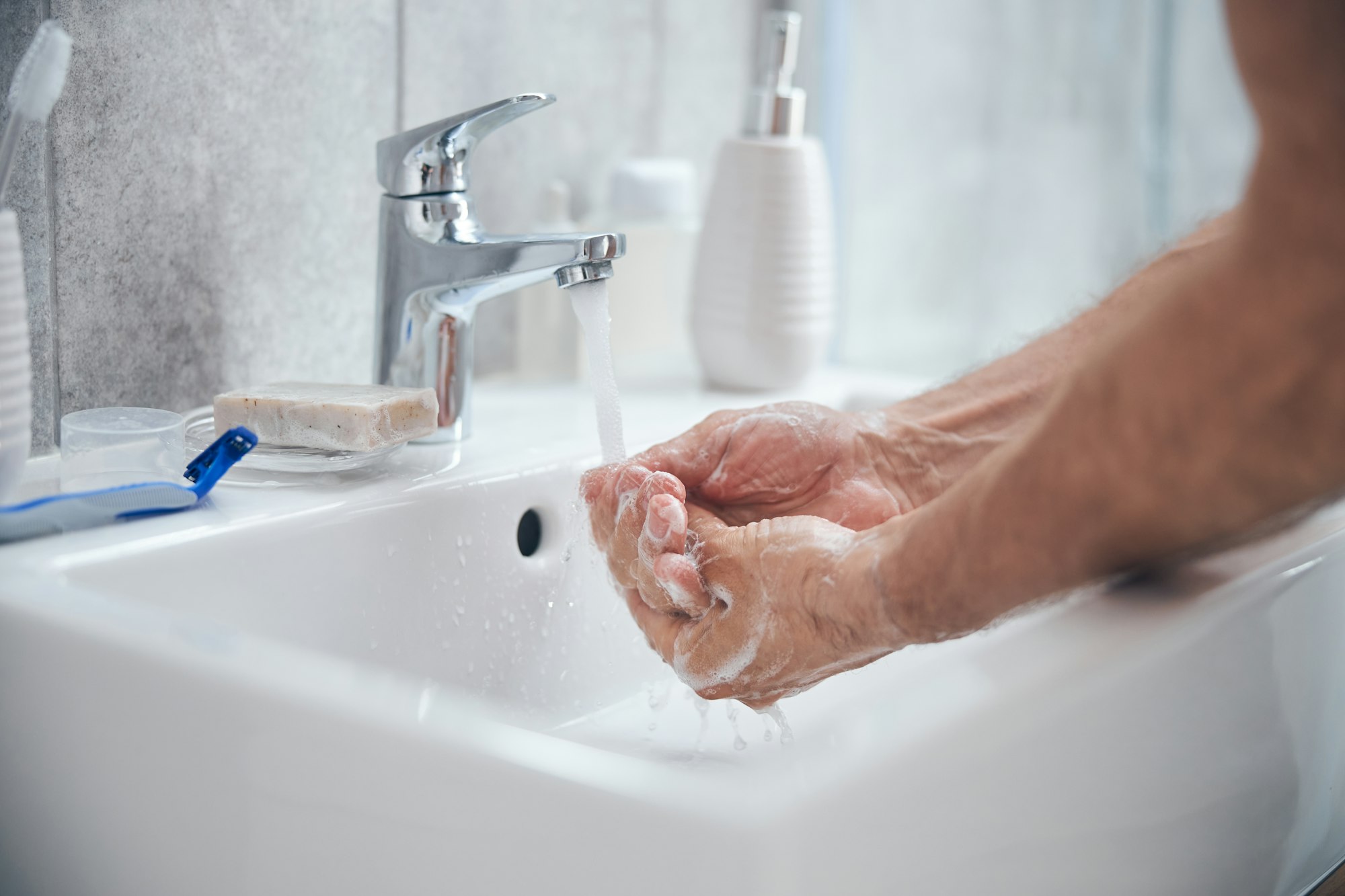 Man holding his cupped palms under running water