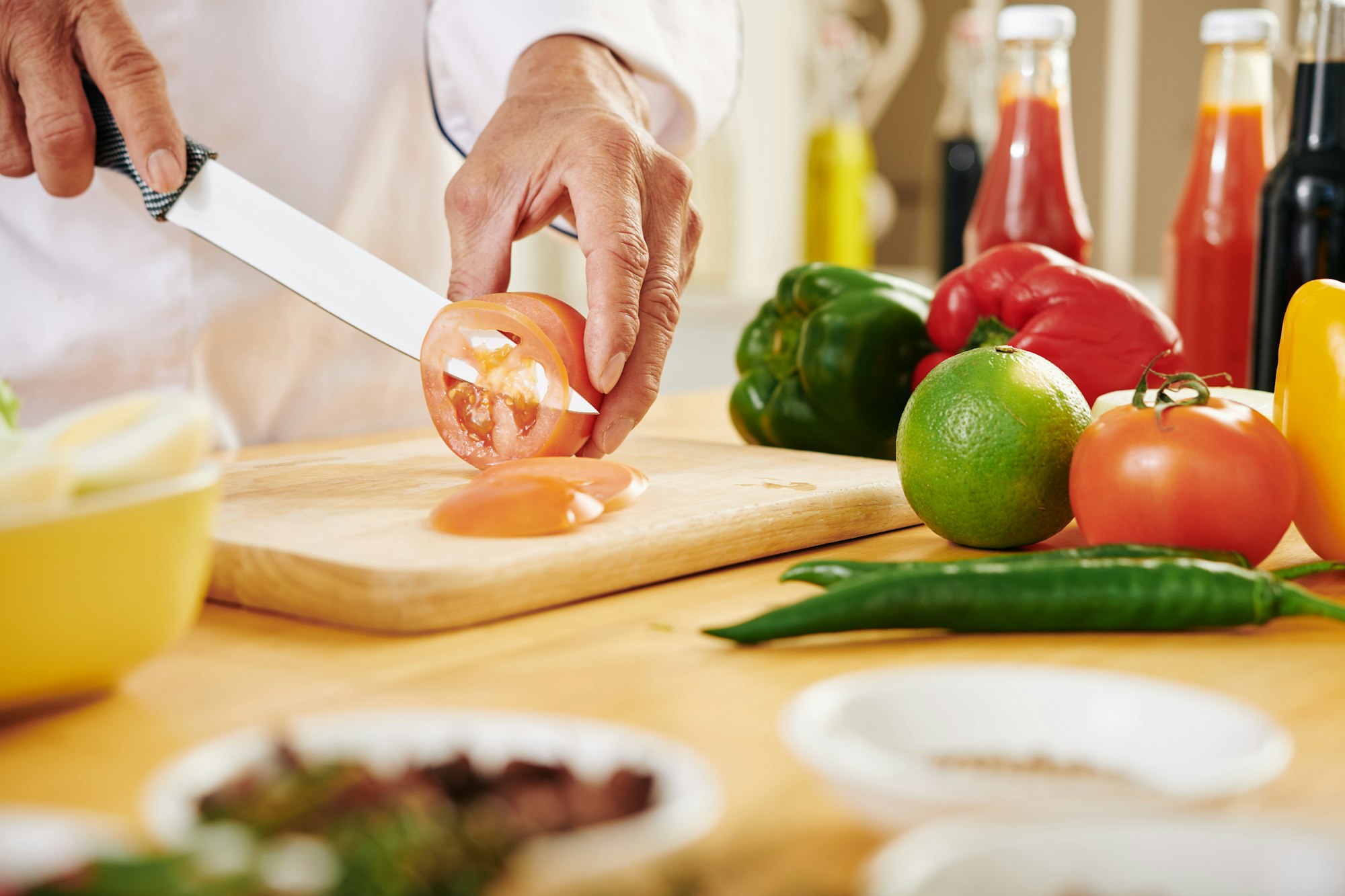 Mature man cutting tomato